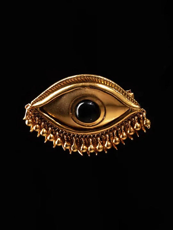 Gaze hair clip in 18-carat gold plating, front view – sculpted eye with engraved lashes, black onyx centre and a fringe of drops