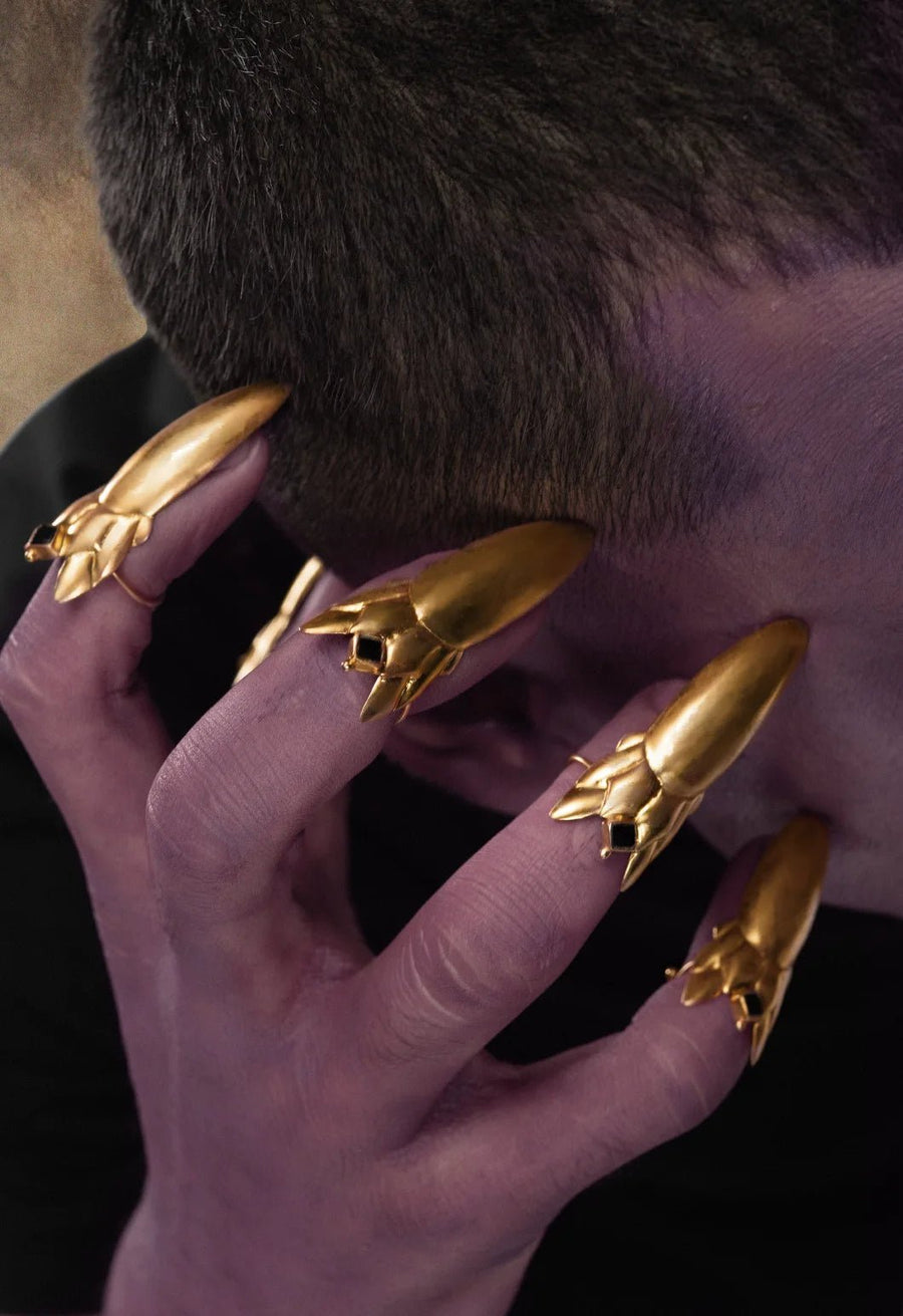 Devil Dagger Nail Ring in 18-carat gold plating on sterling silver, product photo on black – nail rings, Bhavya Ramesh