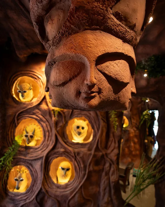 A carved stone face above glowing cave niches